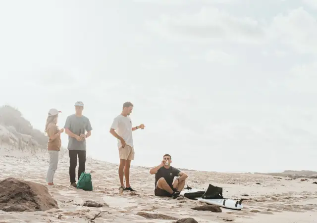 Amigos descansando y conversando en una playa durante un viaje